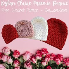 three crochet heart hats on top of pink roses