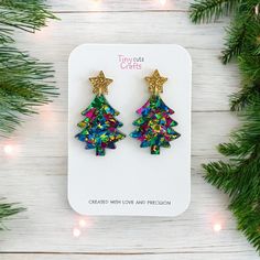 Christmas tree earrings, Xmas gift, glitter earrings, christmas jewelry--these charming Christmas tree earrings are the perfect Christmas gift for her, designed to add festive cheer to any outfit. Adorned with a sparkling gold or silver stud star topper, these earrings are crafted from chunky glitter acrylic in vibrant shades of pink, green, blue, or pastel.  Measuring approximately 1.5" tall and 1" wide, they offer the perfect balance of seasonal style and comfort. With hypoallergenic stainless steel findings, these earrings are not only stylish but also durable and comfortable for long-term wear. Arriving in a gift bag accompanied by a polishing cloth, these earrings are carefully packaged in a shipping box to guarantee their safe journey to you. Should you have any inquiries, please do Blue Earrings For Christmas Gift, Safe Journey, Christmas Party Gift, Charming Christmas, Tree Earrings, Glitter Acrylic, Christmas Tree Earrings, Glitter Earrings, Glitter Acrylics