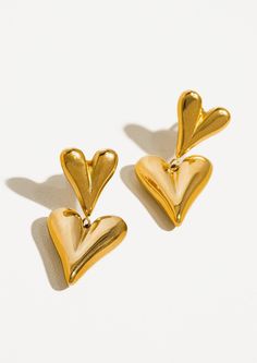 A pair of gold earrings with small heart on top of big heart. Gold Double Heart Nickel Free Earrings, Yellow Gold Metal Earrings For Valentine's Day, Valentine's Day Yellow Gold Metal Earrings, Valentine's Day Yellow Gold Earrings, Gold Double Heart Nickel-free Earrings, Nickel-free Double Heart Gold Earrings, Gold Double Heart Metal Earrings, Nickel-free Gold Double Heart Earrings, Gold Metal Double Heart Earrings