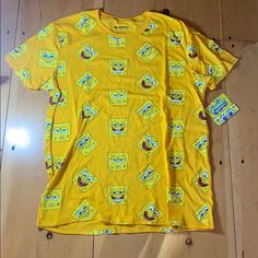 a yellow t - shirt with cartoon characters all over it