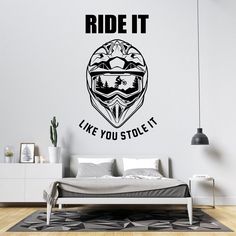 a bedroom with a bed and wall sticker that says ride it like you stole it