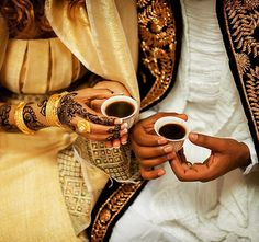 two people holding coffee cups in their hands