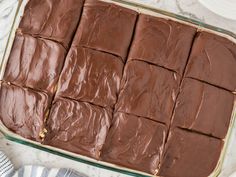 a pan filled with chocolate frosted squares on top of a white and gray table