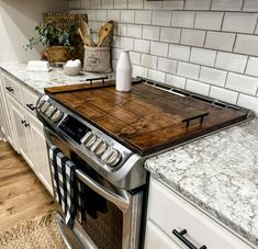 a kitchen with an oven, stove and counter top that has a cutting board on it