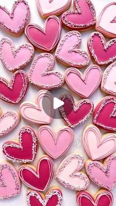 some pink and red heart cookies on a white table