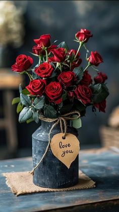 a bouquet of red roses in a vase with a tag that says i love you