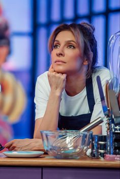 a woman sitting at a table with utensils in front of her and looking up