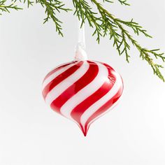 a red and white striped ornament hanging from a tree