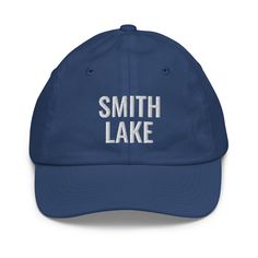 Crafted for comfort and designed for those who love Smith Lake, this embroidered youth-sized hat is sure to become an essential to all your outdoor adventures. Featuring an adjustable strap, it offers a great fit, comfort, and a stylish design. • 100% bio-washed chino cotton twill• Head circumference: 21″–21.57″ (53.3 cm–54.8 cm)• Unstructured, 6-panel, low-profile• Adjustable self-fabric hideaway strap closure• Brass-toned tri-glide buckle• Blank product sourced from Bangladesh Tag us on Instag Curved Bill Hat With Custom Logo For Outdoor, Outdoor Hat With Custom Logo And Curved Brim, Letter Print Cap For Outdoor Activities, Cotton Baseball Cap For Hiking, Adjustable Baseball Cap With Custom Logo For Outdoor, Sporty Outdoor Hat With Embroidered Logo, Outdoor Letter Print Hats, One Size Fits Most, Outdoor Letter Print Hats, One Size, Adjustable Letter Print Hat For Outdoor Activities