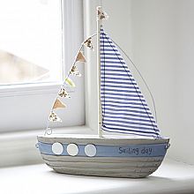 a toy sailboat sitting on top of a window sill next to a window