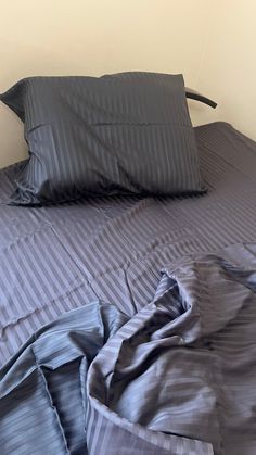 an unmade bed with two pillows on top of it and a pillow case in the middle