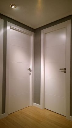 two white doors are open in an empty room