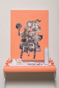 an orange shelf with various items on it and a painting hanging above the shelf in front of it