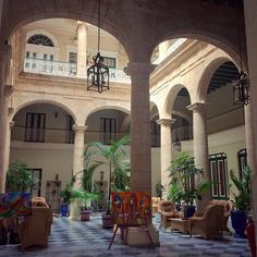 an indoor courtyard with chairs and paintings on the floor