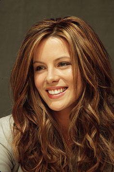 a woman with long hair smiling at the camera