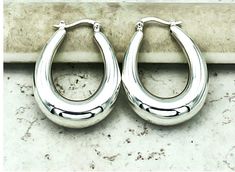 Elevate your jewelry collection with our exquisite 925 sterling silver oval hoop earrings, designed with a convenient latch-back closure. These elegant hoops boast a hollow form construction, ensuring they are both lightweight and comfortable for all-day wear. Each earring measures approximately 1.05 inches in width and 1.27 inches in length, providing a subtle yet impactful addition to any ensemble. Meticulously crafted and stamped with '925' to guarantee authenticity, these earrings are a timeless choice for those who appreciate classic style with a modern twist. Satisfaction Guaranteed! Formal Hypoallergenic Oval Hoop Earrings, Classic Oval Hoop Earrings As Gift, Anniversary Hypoallergenic Oval Hoop Earrings, Hypoallergenic Oval Hoop Earrings For Anniversary, Nickel-free Hoop Earrings For Anniversary, Nickel-free Oval Hoop Earrings For Anniversary, Oval Nickel-free Hoop Earrings For Anniversary, Classic Hoop Earrings Stamped 925 For Anniversary, Classic 925 Stamped Hoop Earrings For Anniversary