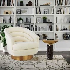 a living room filled with lots of white bookshelves