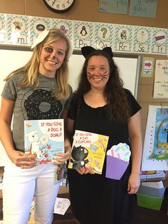 two girls holding up books in front of a clock