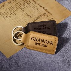 "This keychain is engraved with the phrase \"Grandpa est. [custom year], Pawpaw est. [custom year], Gramps est. [custom year]\" on one side. You can personalize the other side of this keychain with any custom phrase, making it perfect as Gift for Father's Day or gift for grandpa. P R O D U C T ∙ I N F O * Word limit: 8-10 words/side * Materials: The keychain is made from genuine leather * Dimensions: 2 7/8\" x 1 3/8\" H O W ∙ T O ∙ P E R S O N A L I Z E STEP 1: Choose what you want at the drop-d Black Rectangular Keychain Perfect For Gifts, Black Rectangular Keychain For Gift, Personalized Rectangular Keychains, Personalized Rectangular Keychain For Gift, Personalized Rectangular Keychain Gift, Customizable Rectangular Keychains For Gifts, Customizable Rectangular Keychain As Gift, Customizable Rectangular Keychains For Gift, Customizable Rectangular Keychains As Gift