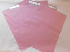 four pink paper bags with silver foil on them