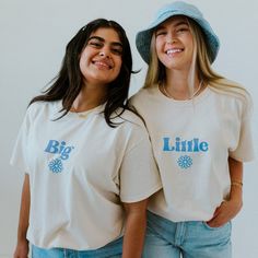 two young women wearing matching shirts and hats