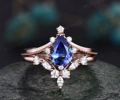 a tan gold ring with a blue stone surrounded by white and clear diamonds on a rock