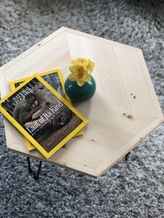 a table with two books and a vase on it