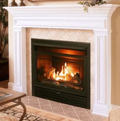 a living room with a fire place in the center and a painting on the wall above it