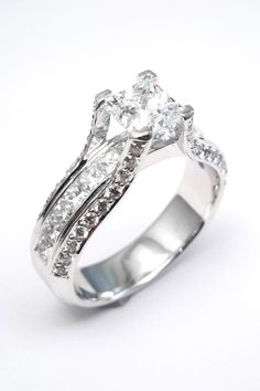 a white gold engagement ring with diamonds on the sides and side stones in the middle