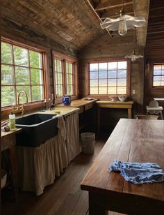 a kitchen with wooden floors and windows next to a table in front of a window