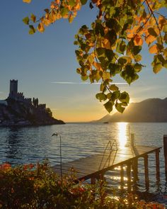 the sun is setting over an island and water