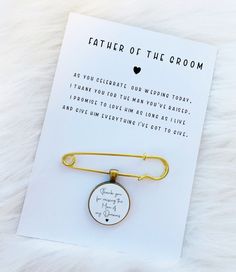 a card that says, father of the groom with a gold tie pin attached to it