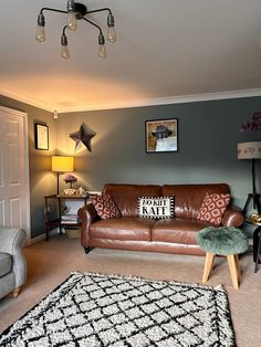 a living room with brown leather couches and rugs on the carpeted floor