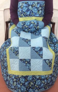 a person sitting in a chair with a quilt on it