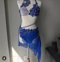 a blue and white belly dance costume on display