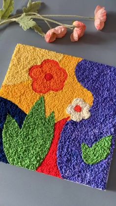 a colorful piece of art with flowers on it