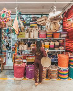 a woman standing in front of many baskets