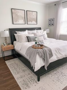 a bed room with a neatly made bed and two pictures on the wall above it