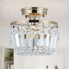 a crystal chandelier hanging from the ceiling in a white and gold colored room