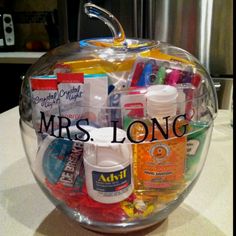 an apple shaped container filled with lots of medicine and other items on top of a counter