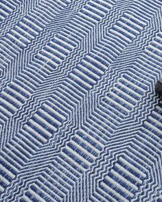 a remote control sitting on top of a blue and white carpeted area with wavy lines