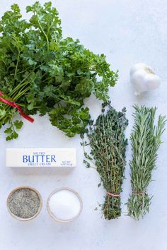 herbs, butter and seasoning on a white surface