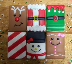 four decorated cookies sitting on top of a wooden table