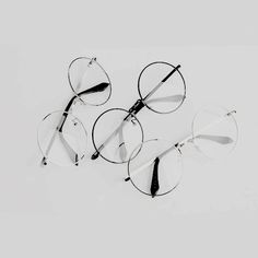 four glasses laying on top of each other in front of a white background, with the lens half closed