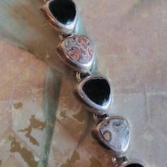 These are vintage, sterling silver, Jasper and black onyx, bracelet. This has tested positive for sterling. There is a little something in the setting of one of the onyx pieces, as you can see in the images. All sales are final. This measures 7.5 inches x 12.5 mm in width. If you have a wish list or are looking for something specific, please ask. I may have exactly what you are looking for. As always please convo me with any questions or concerns regarding this item or with any international shi Vintage Black Jewelry With Natural Stones, Vintage Sterling Silver Bracelet With Natural Stones, Vintage Sterling Silver Bracelets With Natural Stones, Black Sterling Silver Bracelet With Polished Finish, Unique Black Sterling Silver Bracelets, Collectible Black Bracelet Jewelry, Black Onyx Bracelet, Onyx Bracelet, Wish List