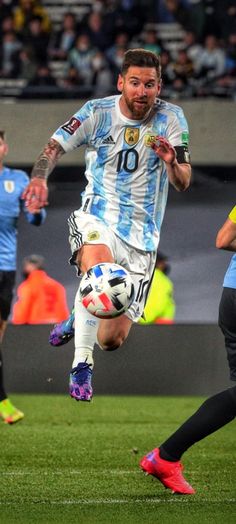 a man kicking a soccer ball on top of a field