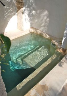 an empty swimming pool in the middle of a house with shadows on the walls and floor