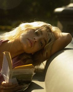 a woman is laying down reading a book