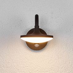 a light that is on the side of a wall with white walls and flooring