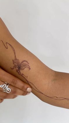 a woman's arm with a flower tattoo on the left side of her arm